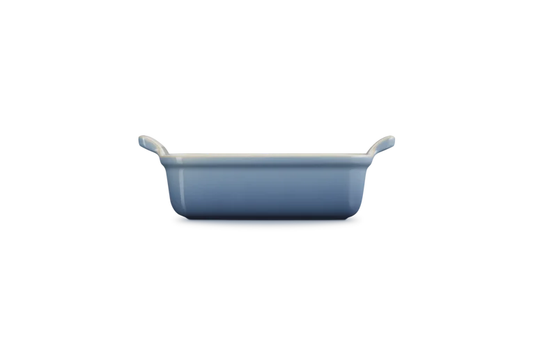 Le Creuset Stoneware Heritage rectangular dish in chambray blue, side view on black background.