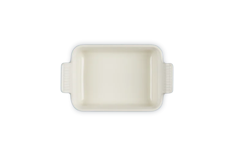 Le Creuset Stoneware Heritage rectangular dish in chambray, shown from above with handles visible.