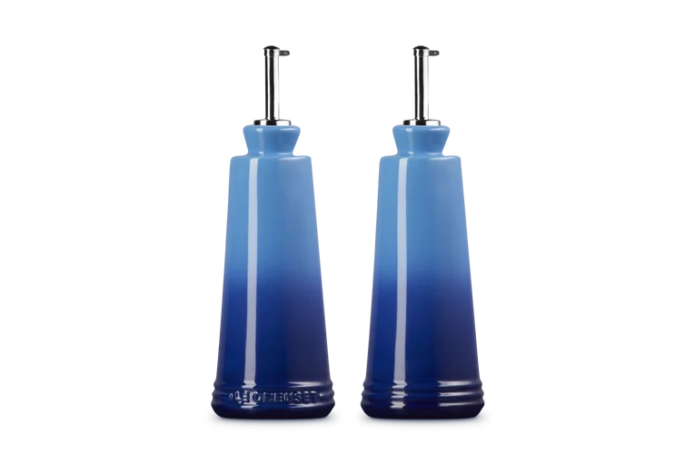 Le Creuset stoneware oil and vinegar set in blue gradient with stainless steel pour spouts, front and back view.