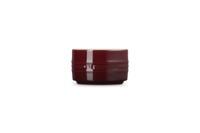 Le Creuset garnet red stoneware ramekin with stackable design and glossy finish, front view.
