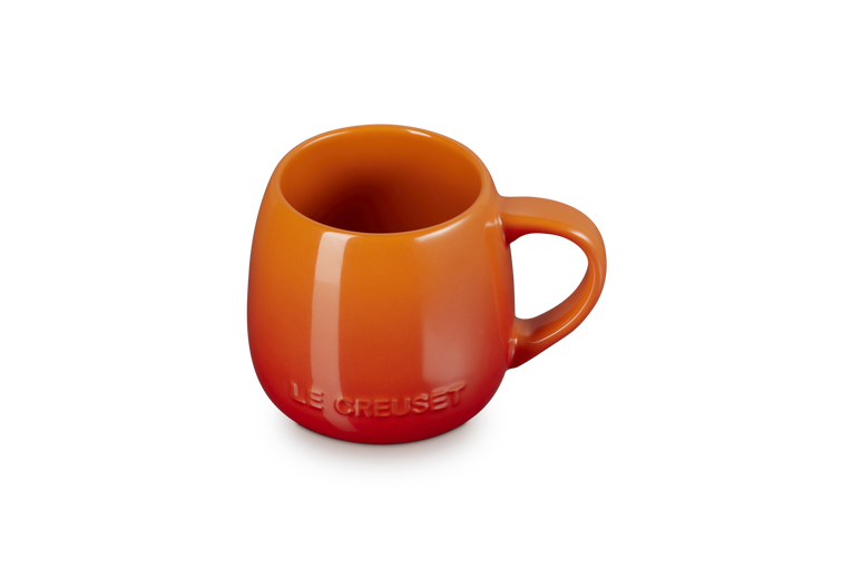 Le Creuset Coupe Mug in volcanic orange with a rounded shape and embossed logo on front.