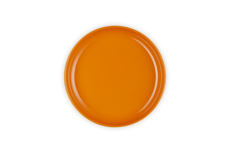 Top view of a bright volcanic orange Le Creuset Coupe Pasta Bowl with a smooth, glossy finish.