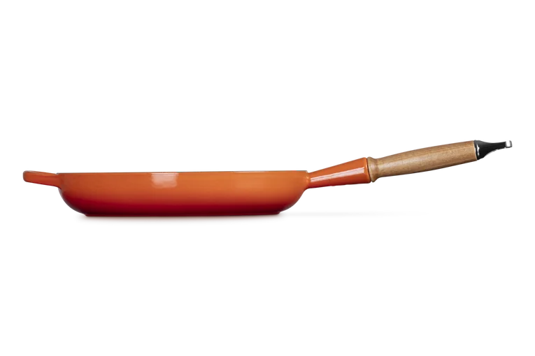 Le Creuset 28cm volcanic cast iron frying pan with wooden handle shown from the side.