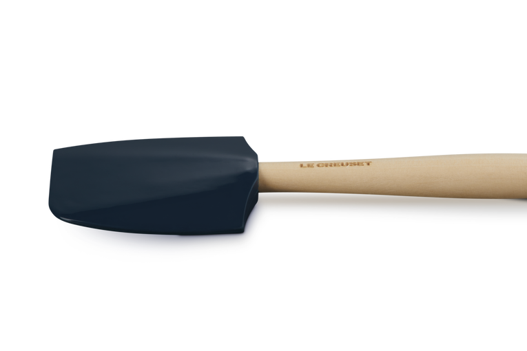Le Creuset Craft Medium Spatula with navy silicone head and light wooden handle embossed with brand name.