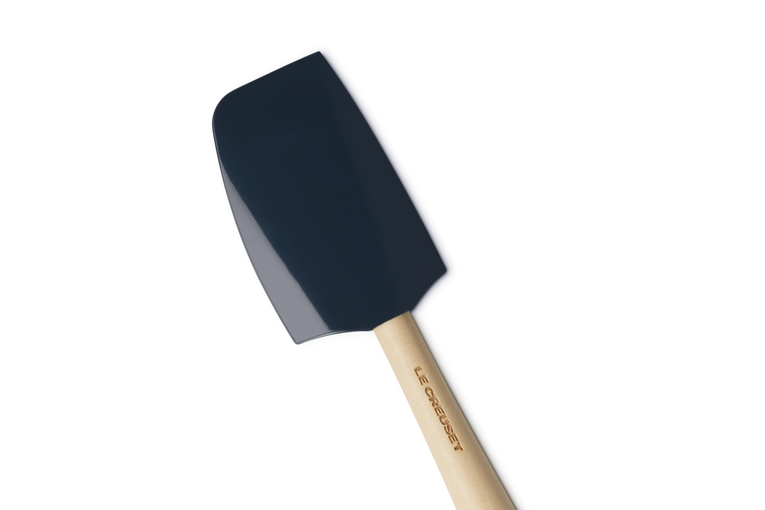 Le Creuset Craft medium spatula with a dark blue silicone head and wooden handle embossed with brand name