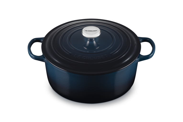 Le Creuset 28cm Signature round casserole in deep blue with lid and metal knob, front angle view.