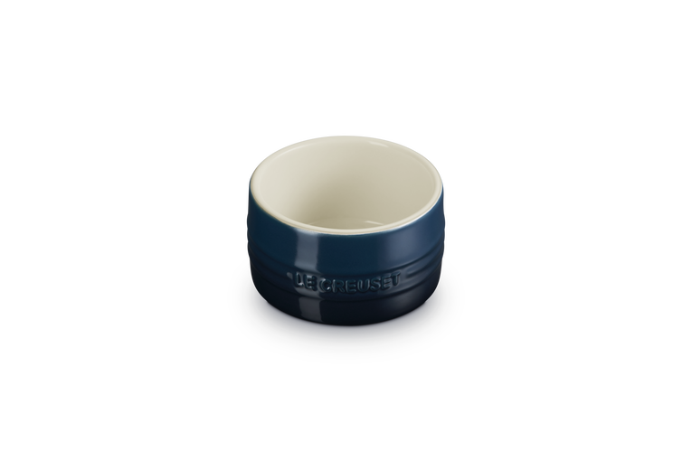 Le Creuset Ramekin 8cm in deep blue with white interior, front view on black background.