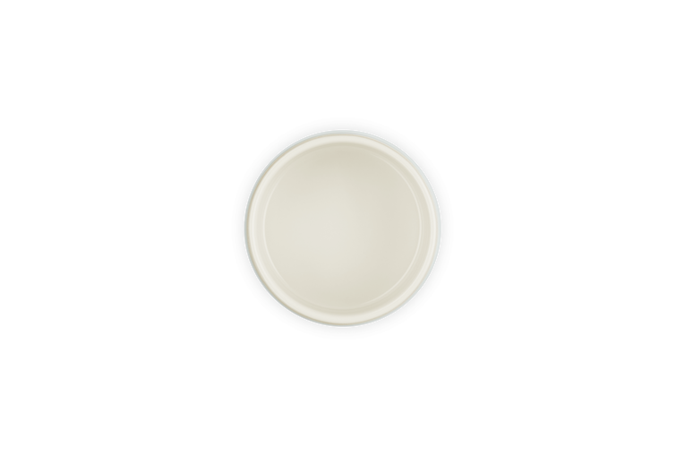 Top view of a round Le Creuset Stackable Ramekin in Sea Salt color with a smooth cream interior and dark outer rim.