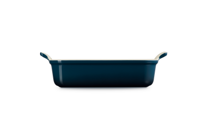 Le Creuset rectangular deep dish in 26cm Nuit blue, shown from the side with handles visible.
