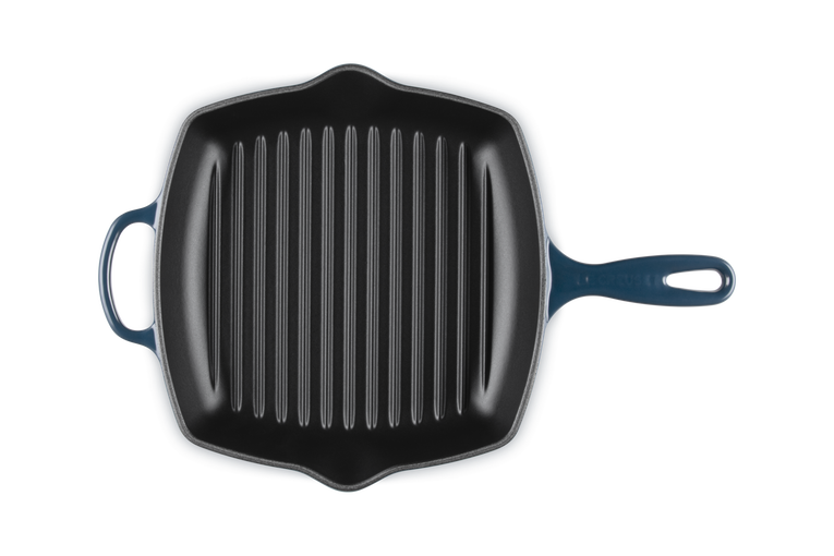 Le Creuset 26cm square cast iron grill pan in Nuit blue with ridged cooking surface and two handles.