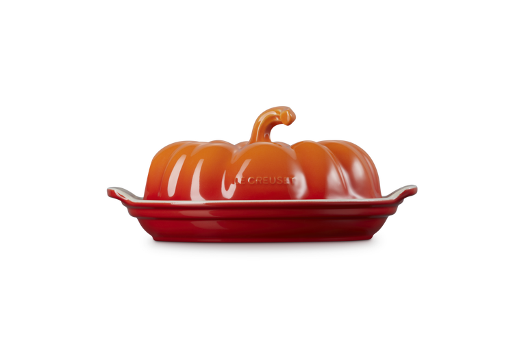 Le Creuset Halloween pumpkin-shaped butterdish in volcanic orange with a lid and base plate.
