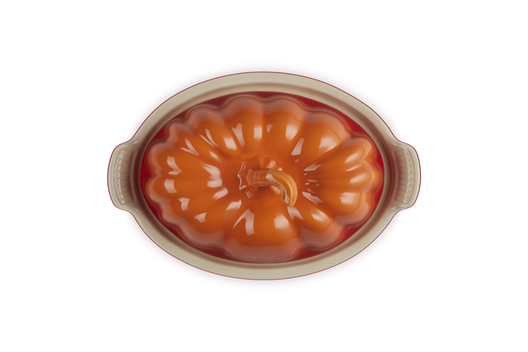 Le Creuset Halloween Pumpkin Butterdish in volcanic orange with pumpkin-shaped lid and cream base, top view.
