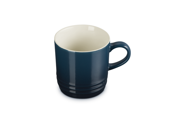 Le Creuset Cappuccino Mug in deep blue with a white interior, shown from a slight top angle.