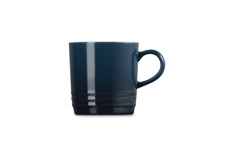 Le Creuset Cappuccino Mug in deep blue Nuit, side view showing handle and ridged base detail.
