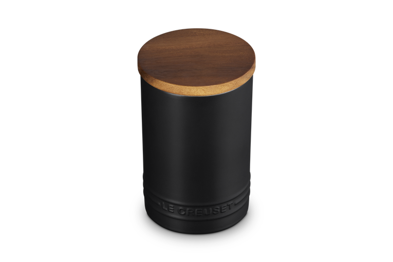 Le Creuset stoneware storage jar in satin black with a round wooden lid, shown from a top-front angle.