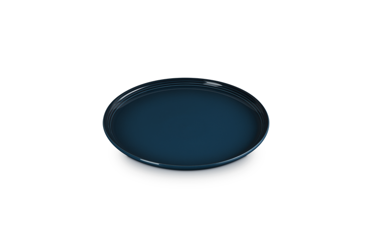 Le Creuset Coupe Side Plate in deep Nuit blue, shown from a slight angle on a white background.