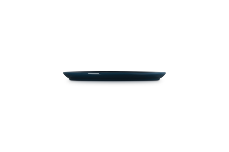 Le Creuset Coupe Side Plate Nuit shown from a low side angle on a black background