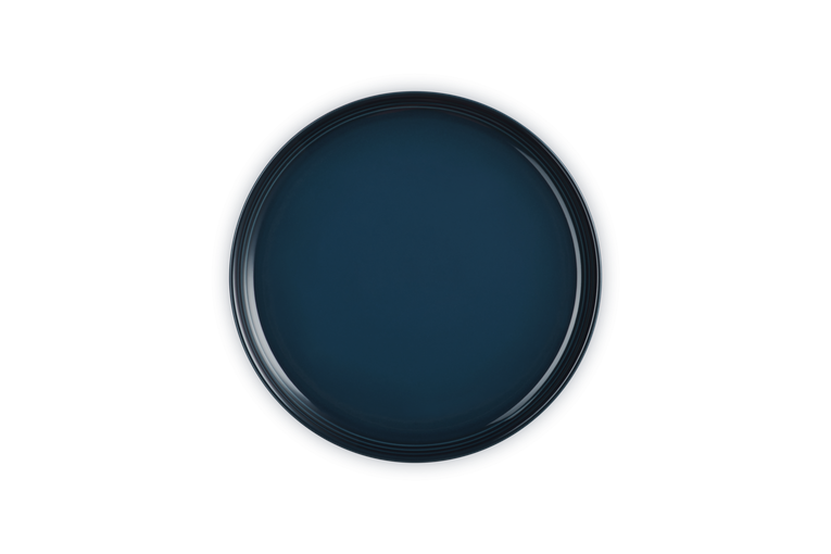 Le Creuset Coupe side plate in deep navy blue with a smooth, glossy finish, top view.