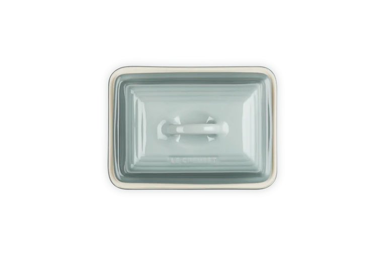 Le Creuset Stoneware Butter Dish in Sea Salt color, top view showing lid with handle and rim detail.