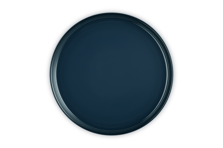 Le Creuset Coupe Dinner Plate in deep blue Nuit with subtle concentric ring detail, top view.