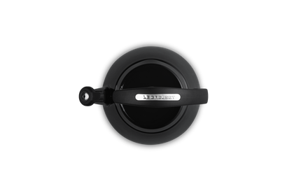 Top-down view of a black Le Creuset Cloche Kettle with a curved handle and spout cover.