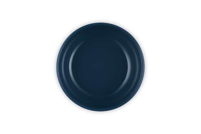 Le Creuset Coupe Serve Bowl in deep navy blue, shown from a top-down view on a white background.