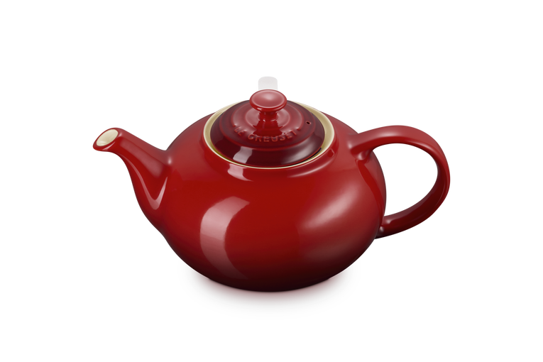Le Creuset Cerise stoneware teapot with lid, rounded body and curved handle, shown at slight angle.