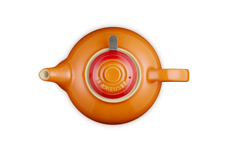 Top view of Le Creuset Stoneware Classic Teapot in volcanic orange with lid and handle visible