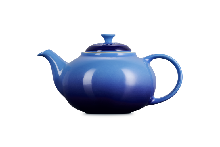 Le Creuset Stoneware Classic Teapot in azure blue with rounded body, curved spout, and handle, shown from side.