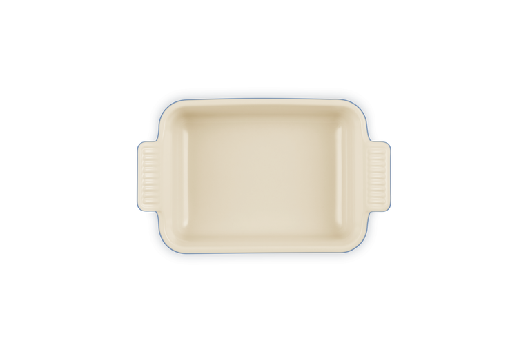 Le Creuset rectangular stoneware dish in cream, shown from above with handles visible.