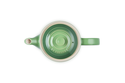 Top view of a green Le Creuset 1.3L Grand Teapot with bamboo lid handle and cream interior rim.