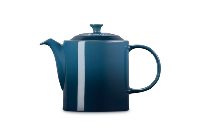 Le Creuset 1.3L Grand Teapot in deep teal with a square body, curved spout, and rounded handle on a white background.