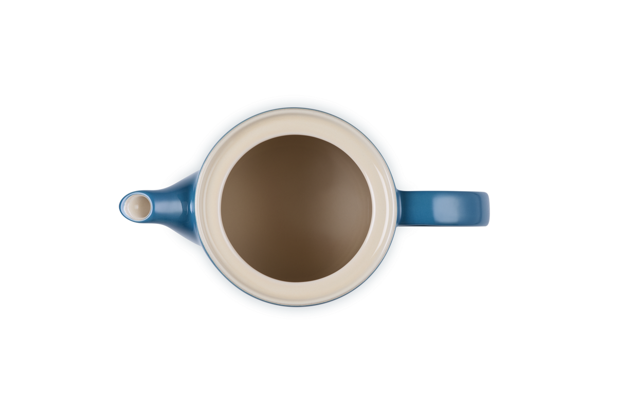 Top view of a deep teal Le Creuset 1.3L Grand Teapot showing its cream-colored interior and handle.