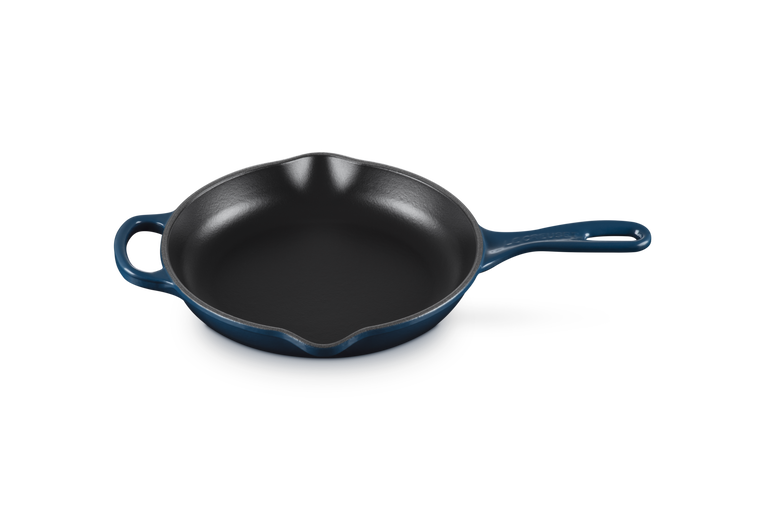Le Creuset 23cm Signature round skillet in Nuit blue with dual pouring spouts and long handle, top view.