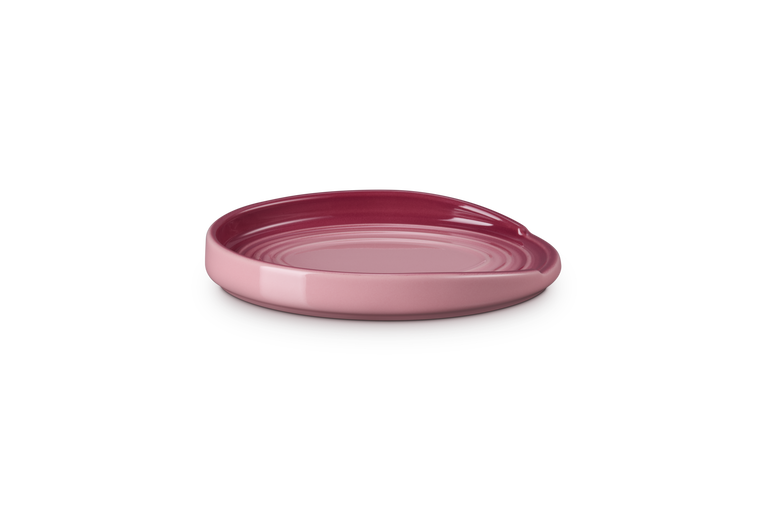 Le Creuset Oval Spoon Rest in rose quartz with a glossy finish and curved edges, side view.