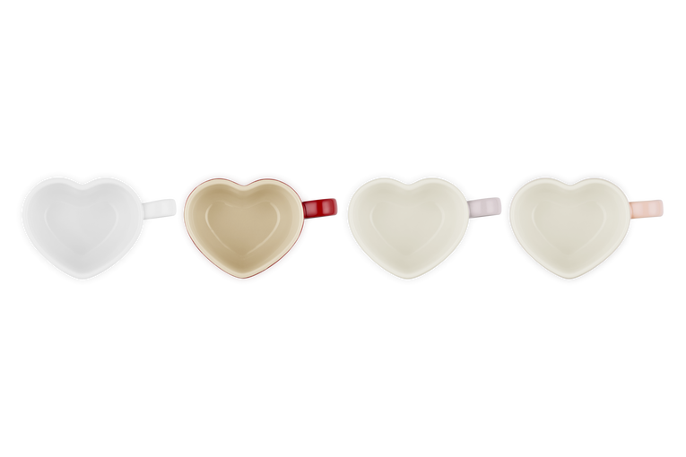 Four heart-shaped mugs in white, beige, light pink, and peach, viewed from above.