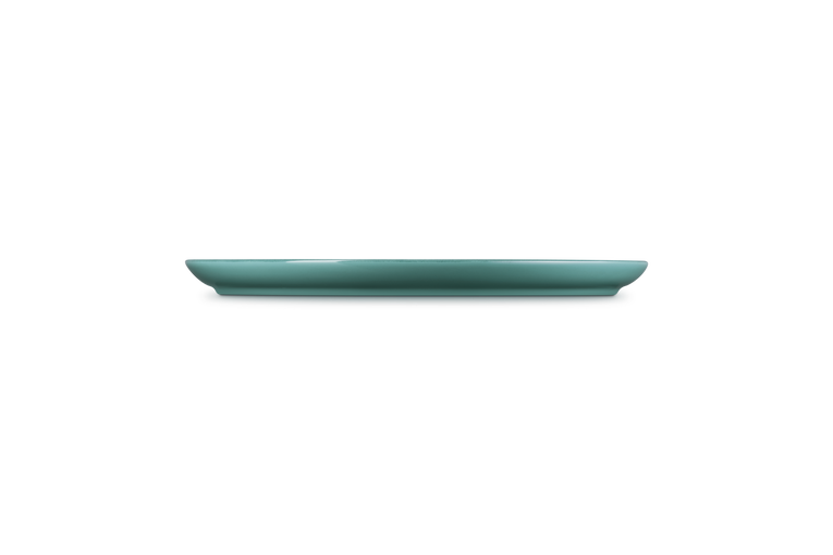 Side view of a blue Le Creuset Coupe Range dinner plate showing its slim profile.