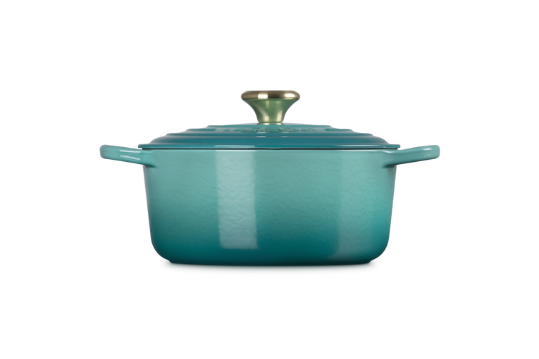 Le Creuset 28cm round casserole in Blue Riviera with lid and gold-tone knob, side view.