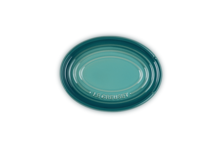 Le Creuset Oval Spoon Rest in Blue Riviera with embossed logo and glossy finish, top view.