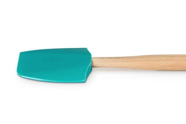 Le Creuset Craft medium spatula with blue Riviera silicone head and wooden handle on black background.