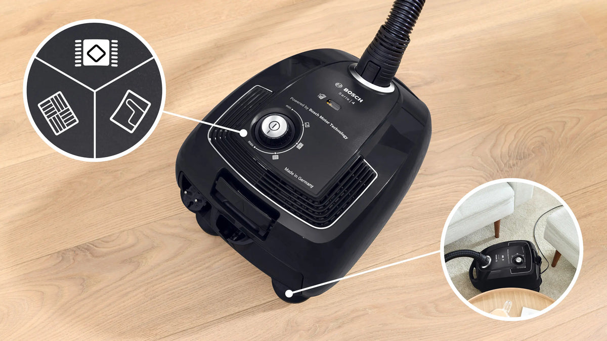 Bosch Series 4 ProEco BGL38BA3GB black vacuum cleaner top view showing power dial and hose connection on wooden floor