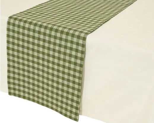 An olive green and cream gingham checkered table runner draped over a white tablecloth.