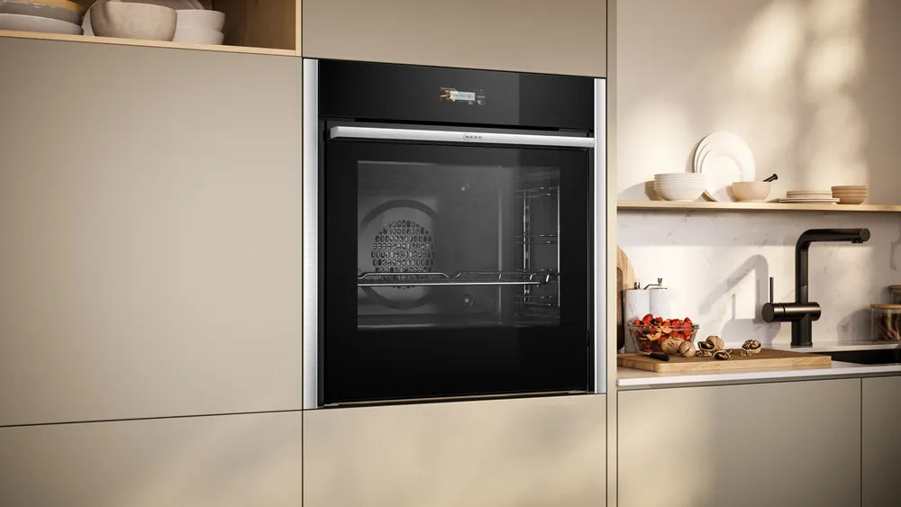 Built-in NEFF N70 Slide&Hide B54CR71N0B electric oven in stainless steel installed in beige kitchen cabinetry.