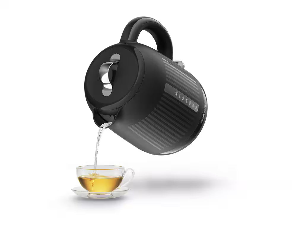 Kenwood Dawn Collection black kettle pouring hot water into a glass teacup on a white background