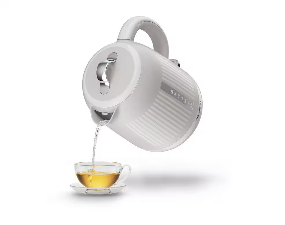 Kenwood Dawn Collection cream kettle pouring hot water into a glass teacup with saucer