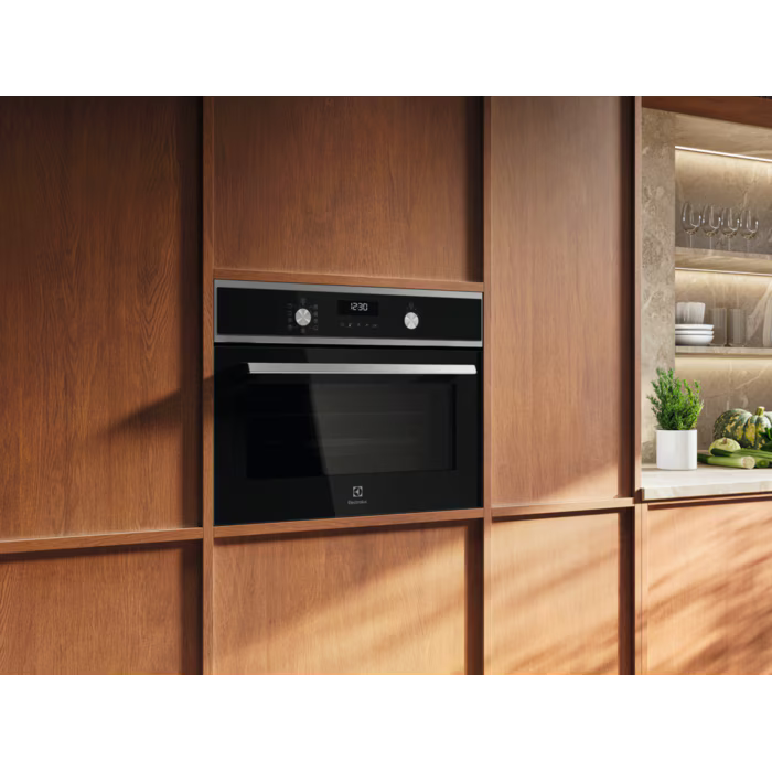 Electrolux 43L compact combi oven built into wooden kitchen cabinetry with digital display and control knobs