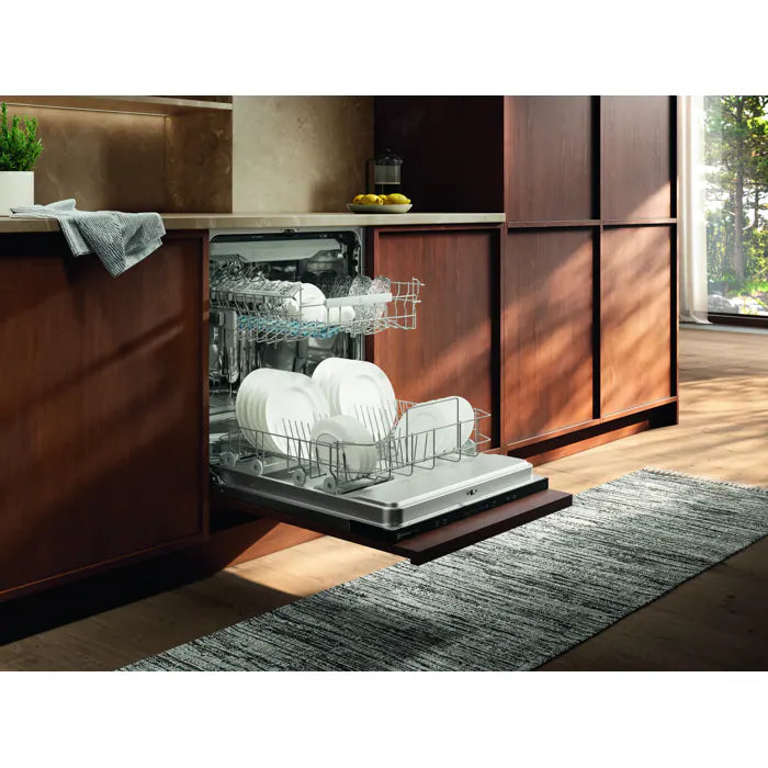 Electrolux integrated dishwasher with open door showing loaded racks of white dishes in a modern kitchen.