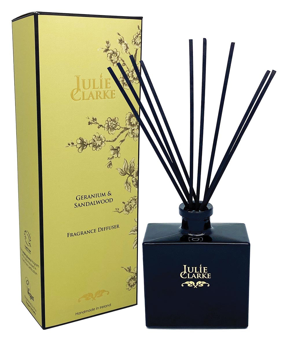Julie Clarke Nocturne diffuser in black glass with reeds beside yellow floral gift box labeled Geranium & Sandalwood