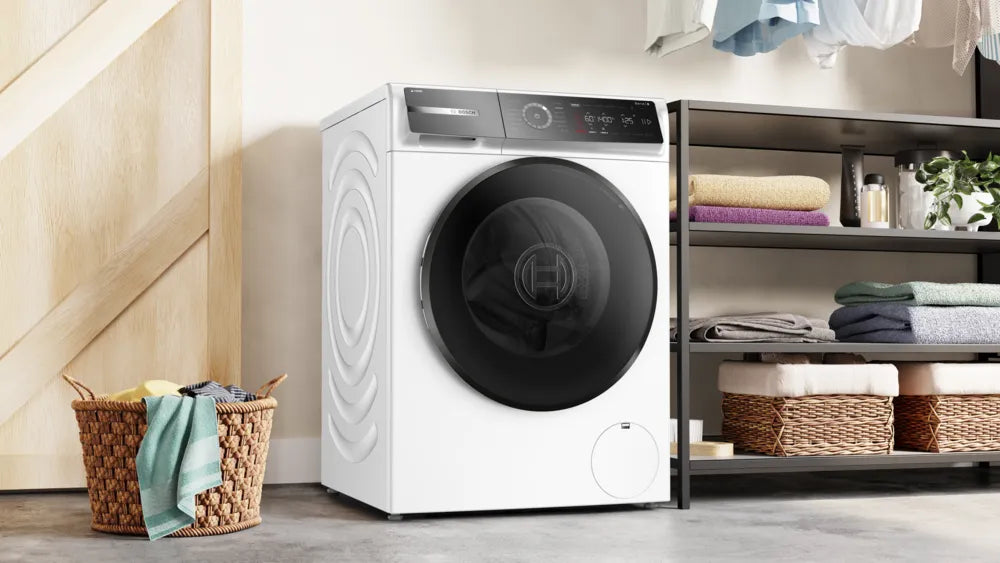 Bosch Series 8 front-loading washing machine in white with black door, digital display, in a laundry room setting.