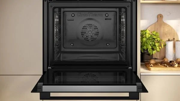 Open Neff B2DCG7AK3B built-in electric oven showing the interior cavity and fan at the back.